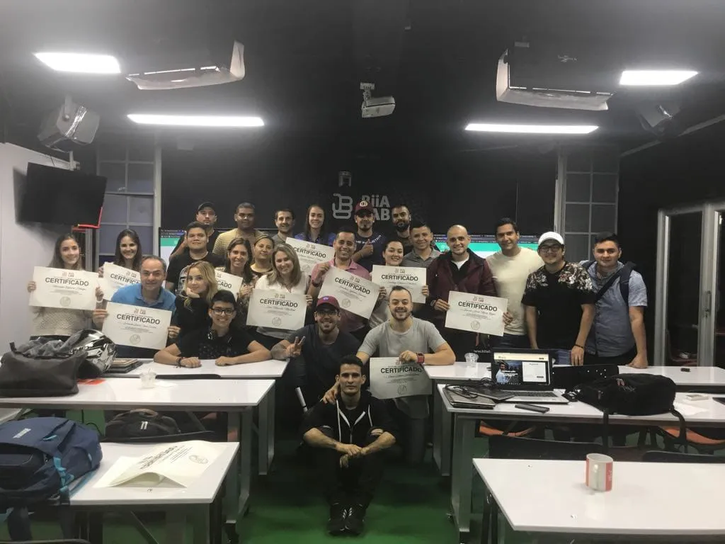 Josué Moya de la Cruz con un grupo de estudiantes que muestran sus certificados en BiiA LAB, Medellín